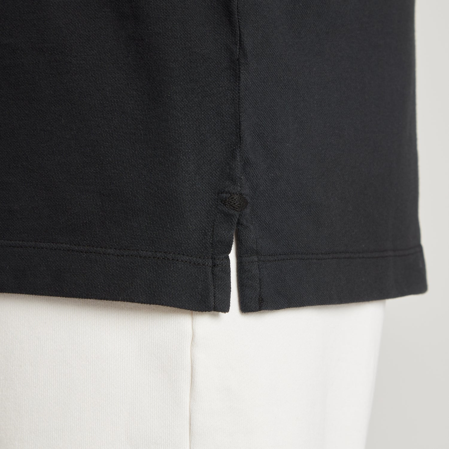 Maglia uomo in micro piquet nero con dettaglio cuciture e spacchetti laterali, comfort premium
