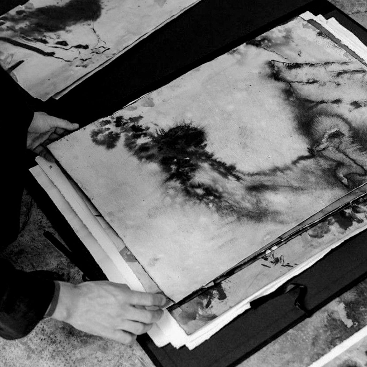 Mani che esaminano opere d'arte astratte in bianco e nero, progetti creativi a Venezia